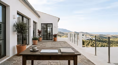 Morning terrace, soft light, minimal table setup (coffee, closed laptop, slim book/folder), Mediterranean home, wide frame with room for overlays